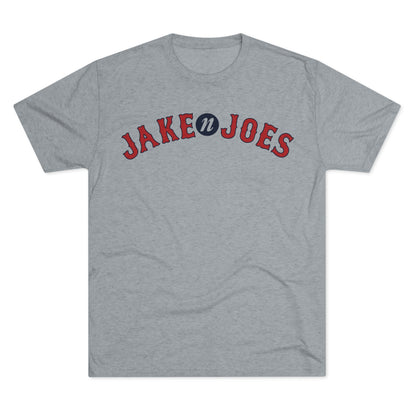 Grey tri-blend short-sleeve t-shirt featuring a red and blue Jake n JOES Boston baseball-style logo on the chest.