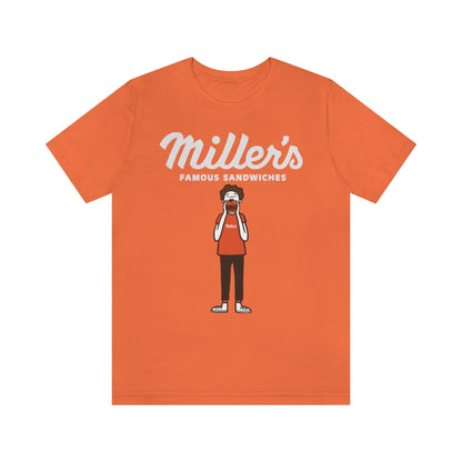 Orange short sleeve cotton tee featuring a Miller's Famous Sandwiches graphic of a person eating a burger.
