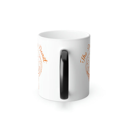 11oz white ceramic mug with a black C-shaped handle and orange The Daily Donut graphic design.