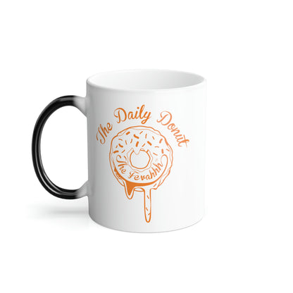 11oz white ceramic mug with a black C-shaped handle and an orange The Daily Donut graphic design.