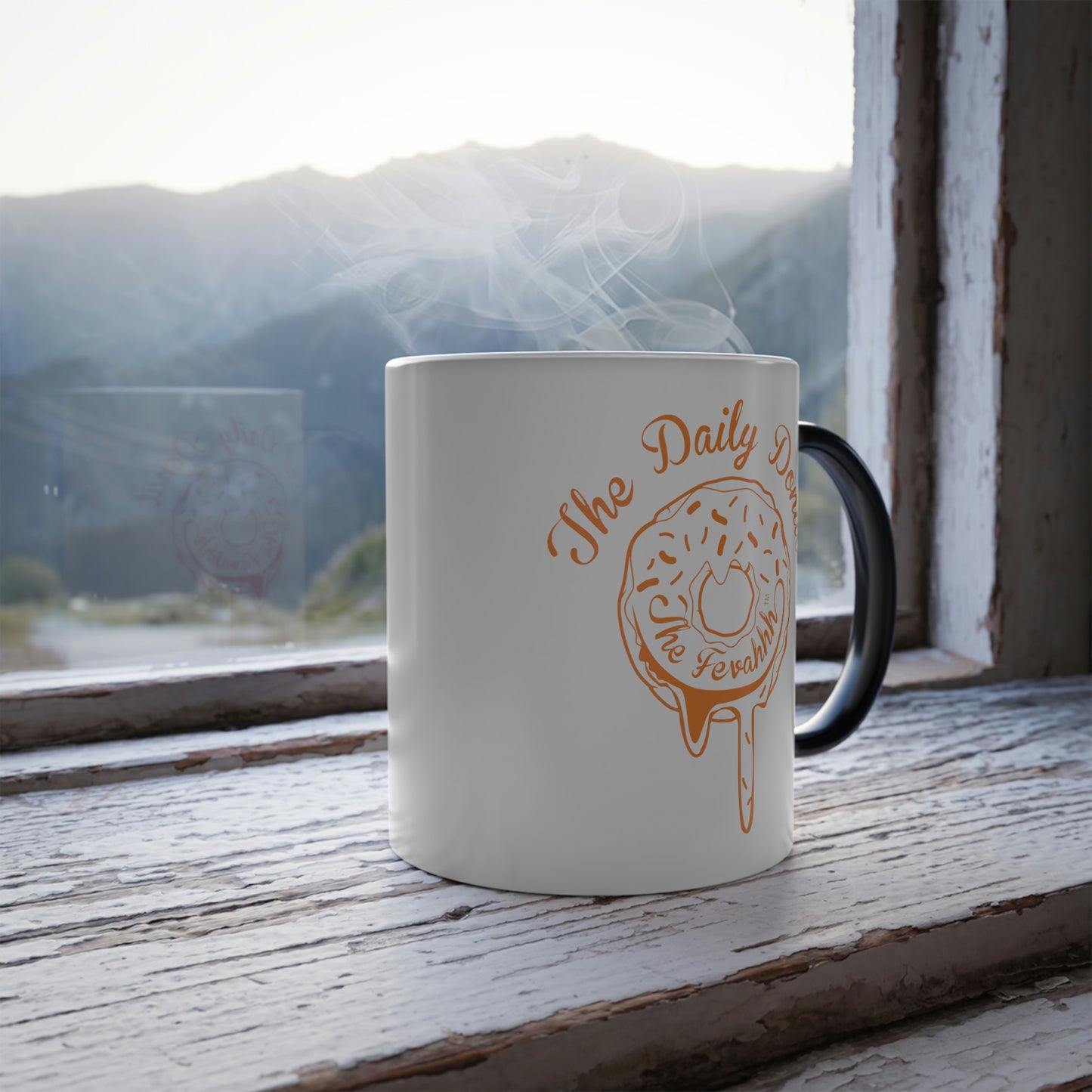 11oz heat-reactive ceramic mug with a white exterior, black handle, and orange donut graphic on a rustic windowsill.