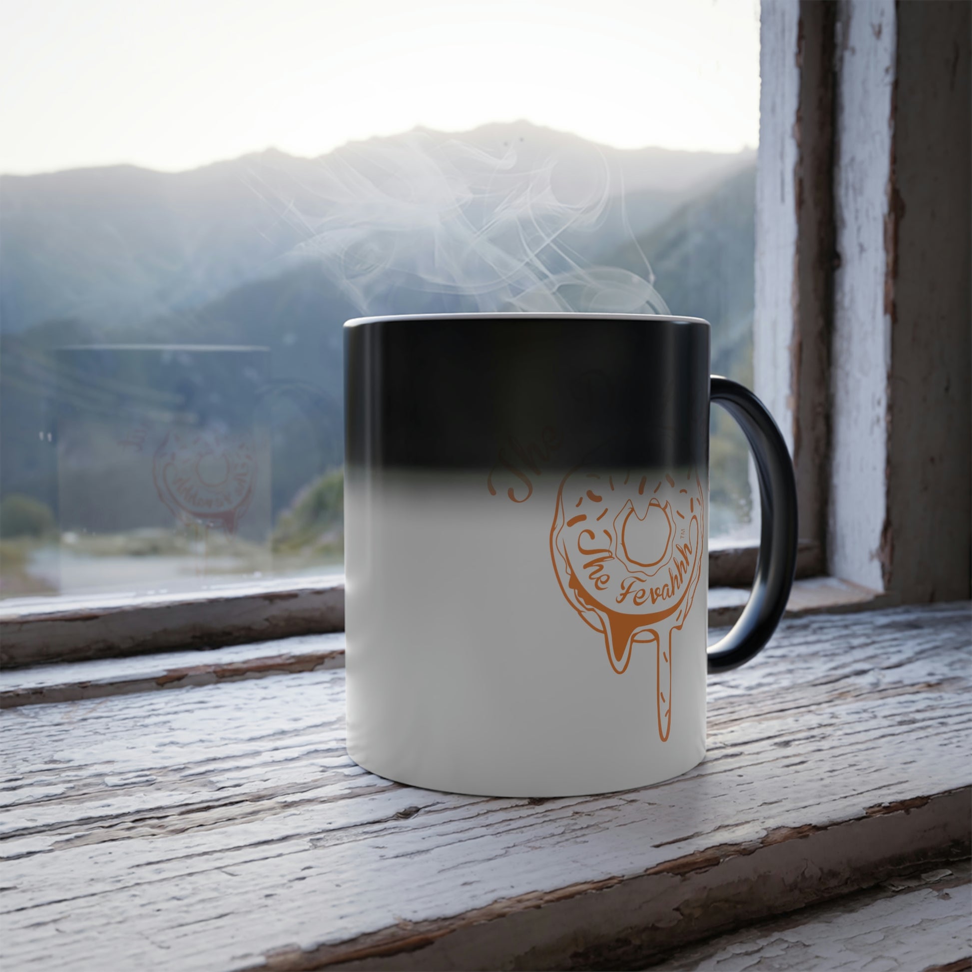 11oz ceramic heat-reactive mug transitioning from black to white with a steaming donut design on a rustic windowsill.