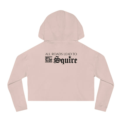 Light pink women's cropped hooded sweatshirt featuring black text on the back that reads All Roads Lead to The Squire.