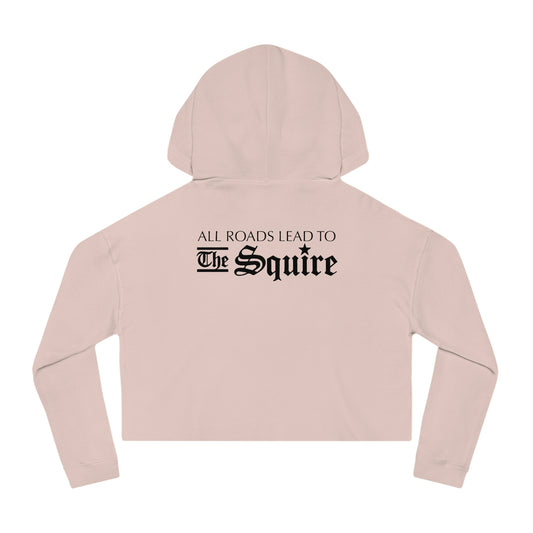 Light pink women's cropped hooded sweatshirt featuring black text on the back that reads All Roads Lead to The Squire.